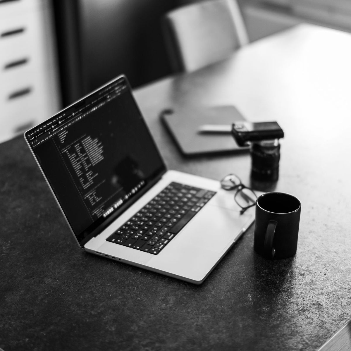 Laptop with code on screen, coffee mug nearby
